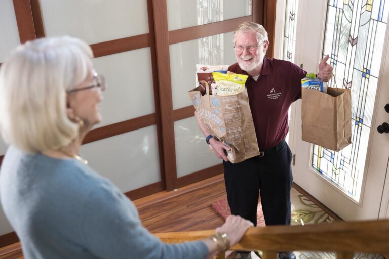 A volunteer delivers groceries to a patient